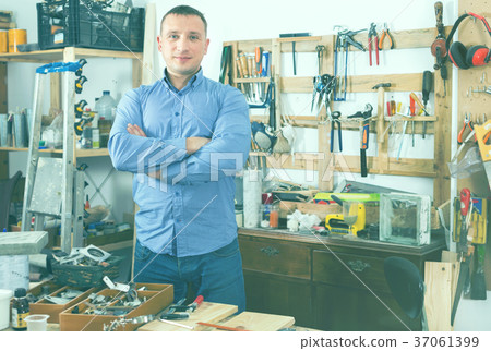 Portrait of attractive smiling adult man in garage. 37061399