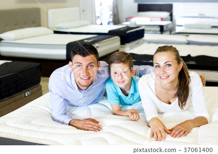 Parents with young son testing mattress Parents with young son testing mattress 37061400
