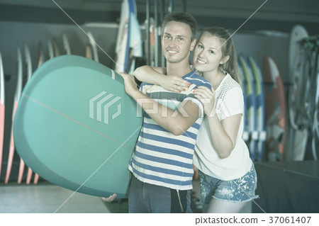 Couple demonstraiting new surfboard Couple demonstraiting new surfboard 37061407