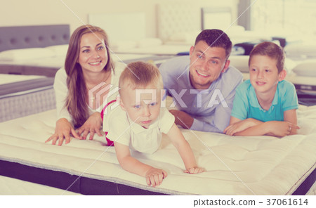 Little boy crawling on bed in salon, testing quality of mattress Little boy crawling on bed in salon, testing quality of mattress 37061614