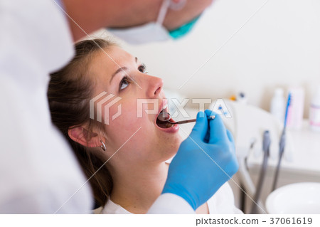 Orthodontist in white is taking examination of a patient 37061619