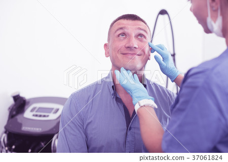 Female doctor is examining face of client after procedure Female doctor is examining face of client after procedure 37061824