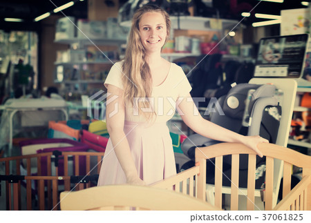 Nice pregnant woman choosing cot for baby Nice pregnant woman choosing cot for baby 37061825