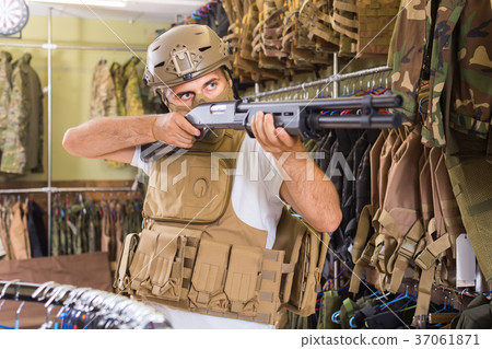 guy in military equipment with gun in airsoft shop guy in military equipment with gun in airsoft shop 37061871