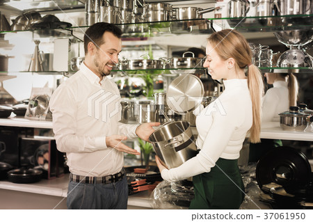 Assistant helping customer to choose saucepan 37061950