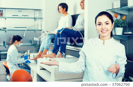 Young nail salon master inviting clients to procedure 37062700