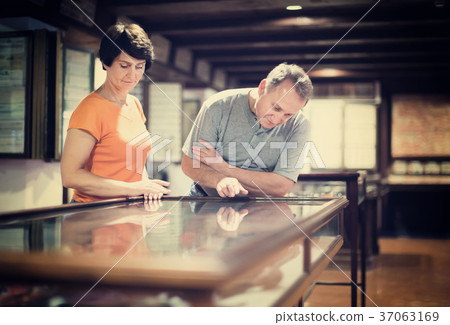Romantic elderly couple interested in objects of applied arts in museum Romantic elderly couple interested in objects of applied arts in museum 37063169