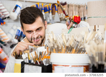 Smiling man choosing new brush for hobby 37063205