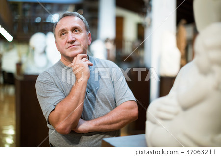 Portrait of male visitor who is looking at the exposition in historical museum. Portrait of male visitor who is looking at the exposition in historical museum. 37063211