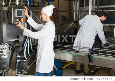 Couple bottling milk on manufacture 37063327