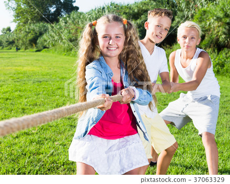 Children playing tug of war outdoors 37063329