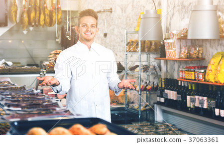 Shop-boy in special clothing shifting sausage Shop-boy in special clothing shifting sausage 37063361