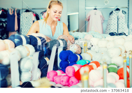 Female in the dresshop choosing thread for knitting 37063418