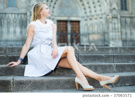 woman in shawl sitting on stone steps woman in shawl sitting on stone steps 37063571