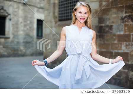 smiling woman holding dress in the hand 37063599