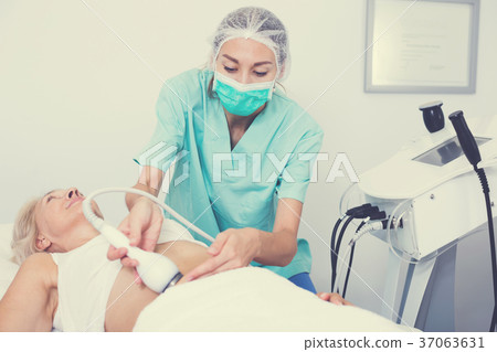 Professional cosmetician performing cryolipolyse 37063631