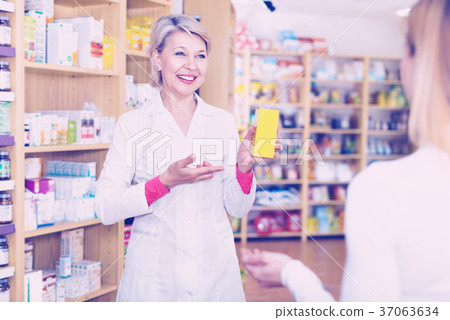 Mature female seller suggesting care products to young customer Mature female seller suggesting care products to young customer 37063634