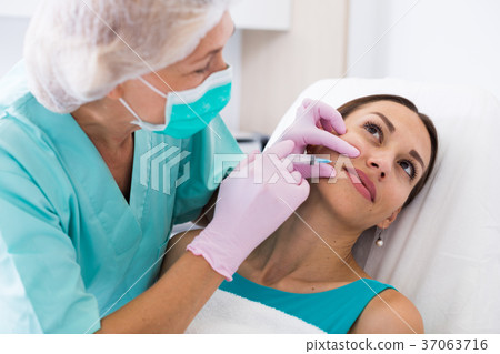 Young woman getting facial injection Young woman getting facial injection 37063716