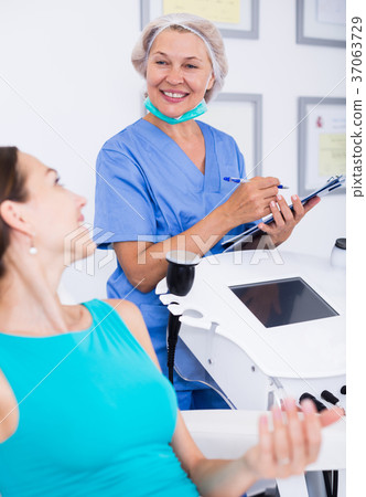 Doctor beautician discussing with woman Doctor beautician discussing with woman 37063729