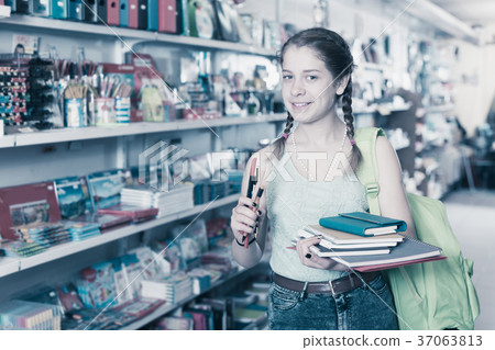 Girl choosing color markers and copybook Girl choosing color markers and copybook 37063813