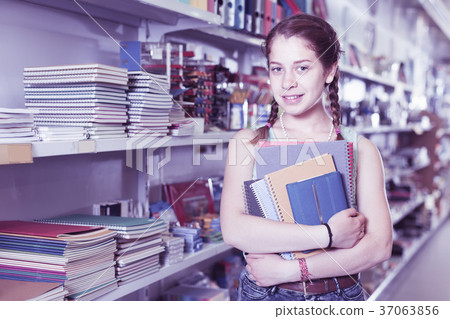 Enthusiastic young girl buying products in stationery shop Enthusiastic young girl buying products in stationery shop 37063856