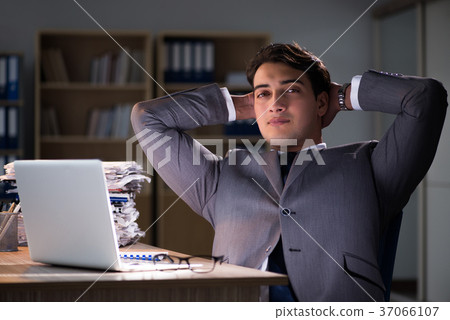 Man staying in the office for long hours Man staying in the office for long hours 37066107