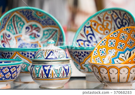 Plates, tajines and pots made of clay on the souk Plates, tajines and pots made of clay on the souk 37068283