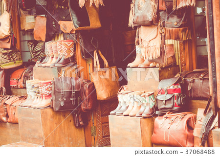 Moroccan leather goods bags and slippers at market 37068488