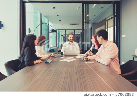 Group of business people meeting in a meeting room, sharing thei 37068898
