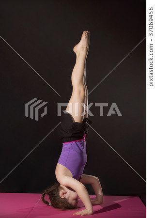 Little caucasian girl practing headstand pose 37069458
