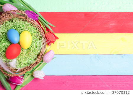 Painted eggs in a basket and tulips 37070312
