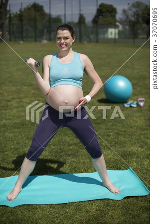 Young pregnant woman exercises with fitball in the Young pregnant woman exercises with fitball in the 37070695