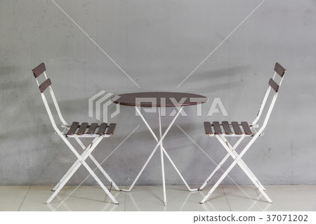 Small table and chairs near grunge wall Small table and chairs near grunge wall 37071202