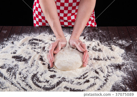 Cook preparing dough for baking in the kitchen 37075089