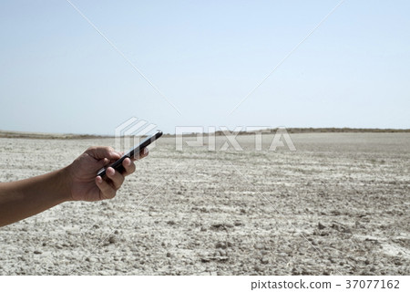 man using a smartphone in the desert 37077162