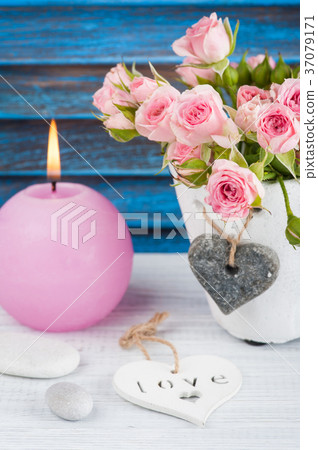 Pink roses in concrete pot with candle 37079171