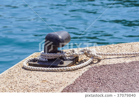 Old metal dock mooring pole with ring and rope for 37079840