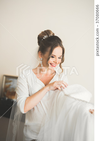 Gorgeous bride in robe posing and preparing for Gorgeous bride in robe posing and preparing for 37080666