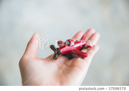 hand holding red toy plane hand holding red toy plane 37086578
