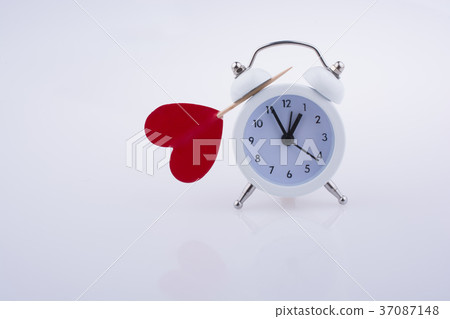 White color alarm clock and red heart shape White color alarm clock and red heart shape 37087148