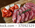 Slices of meat being seasoned for preparation. 37092329