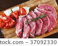 Slices of meat being seasoned for preparation. 37092330