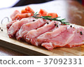 Slices of meat being seasoned for preparation. 37092331