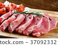 Slices of meat being seasoned for preparation. 37092332