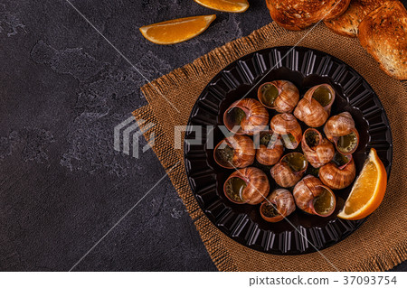 Fried snails with lemon, baguette and parsley. 37093754
