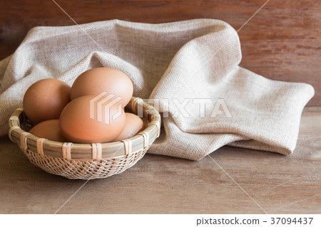 raw chicken egg in bamboo basket on wooden table raw chicken egg in bamboo basket on wooden table 37094437