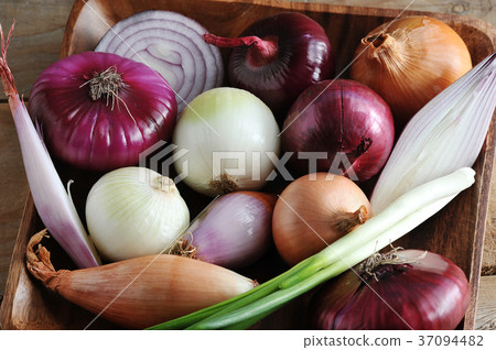 different onion varieties in a wooden plate  37094482