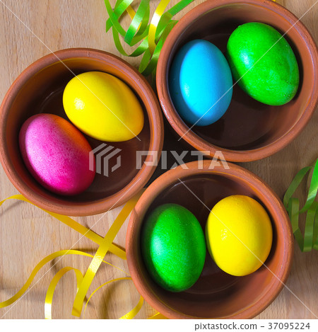 Colored decorated Easter eggs in clay bowls 37095224