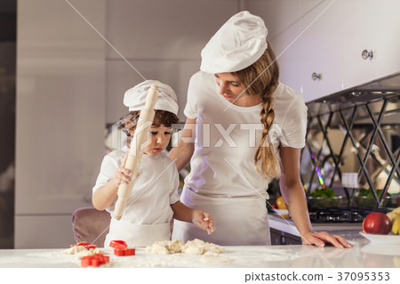 Young mother baking together with her little son Young mother baking together with her little son 37095353