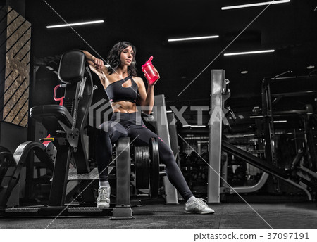 Beautiful young girl athlete bodybuilder, sitting in the gym, re Beautiful young girl athlete bodybuilder, sitting in the gym, re 37097191